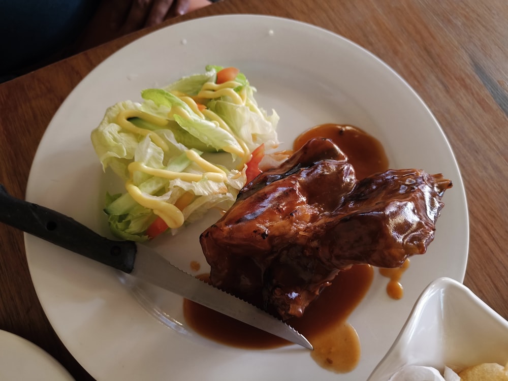 a white plate topped with meat covered in gravy