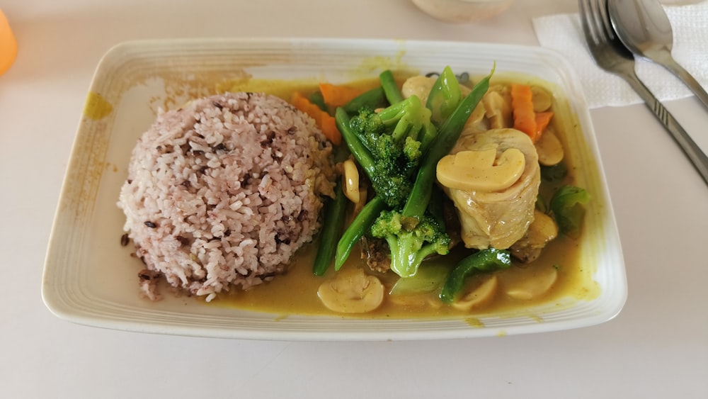 un plato blanco cubierto con carne y verduras