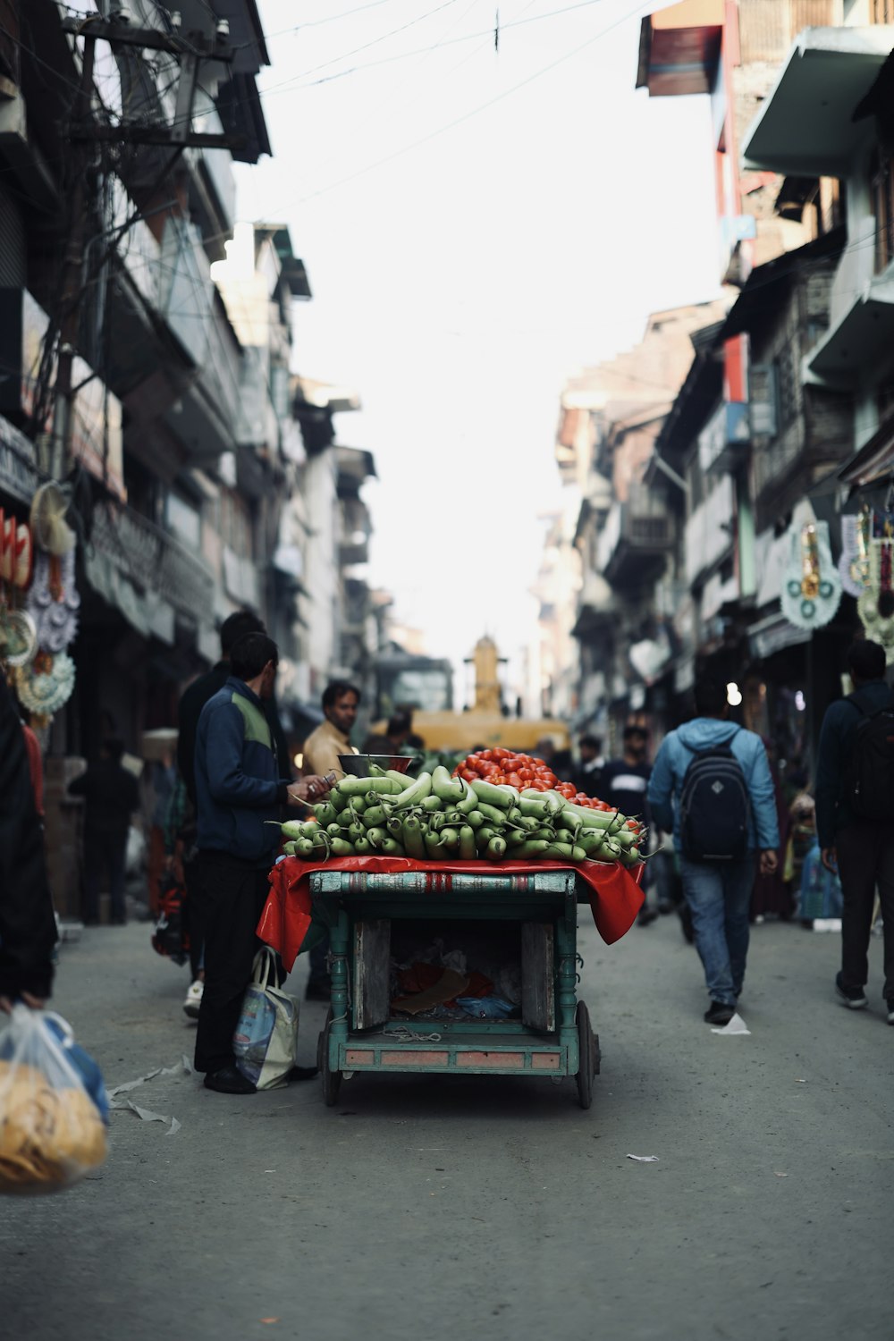 a man is pushing a cart full of produce down the street