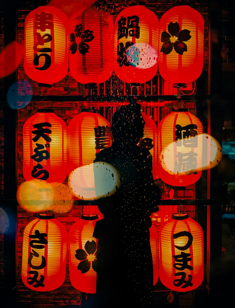 a person standing in front of a display of lanterns