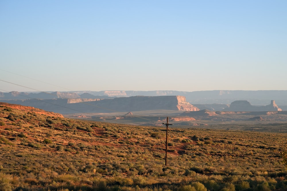 a view of a mountain range with a telephone pole in the foreground