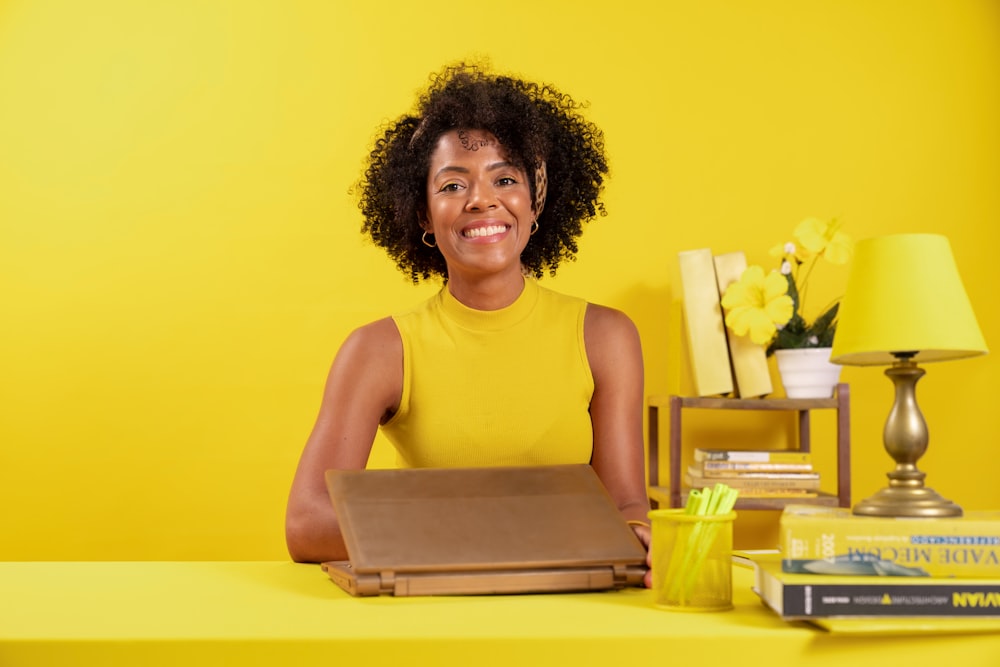 uma mulher sentada em uma mesa com um laptop