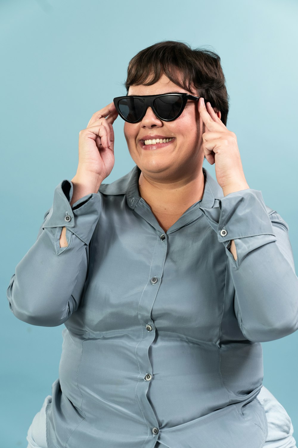 a woman in a blue shirt and black sunglasses