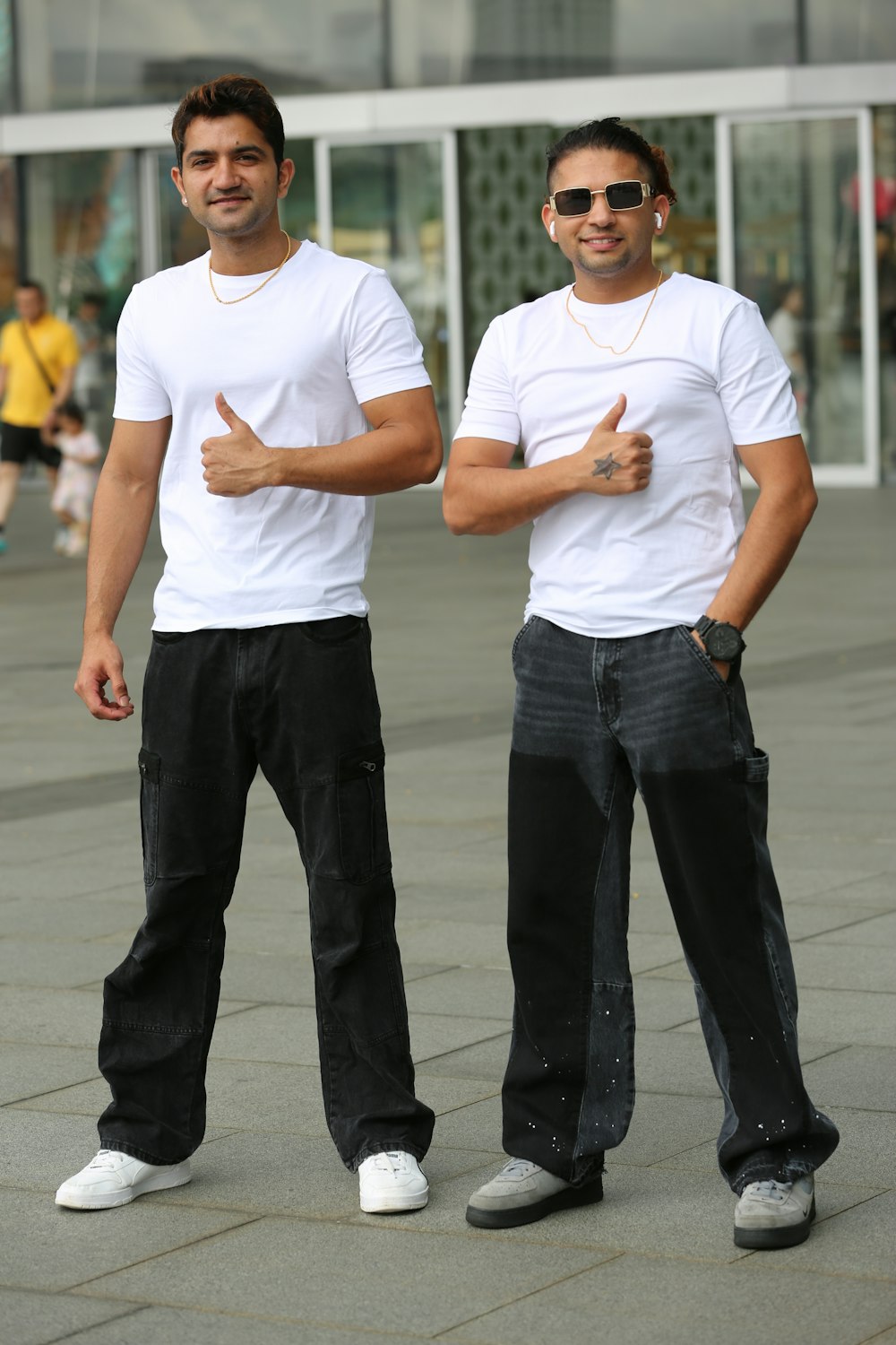 two men standing next to each other in front of a building