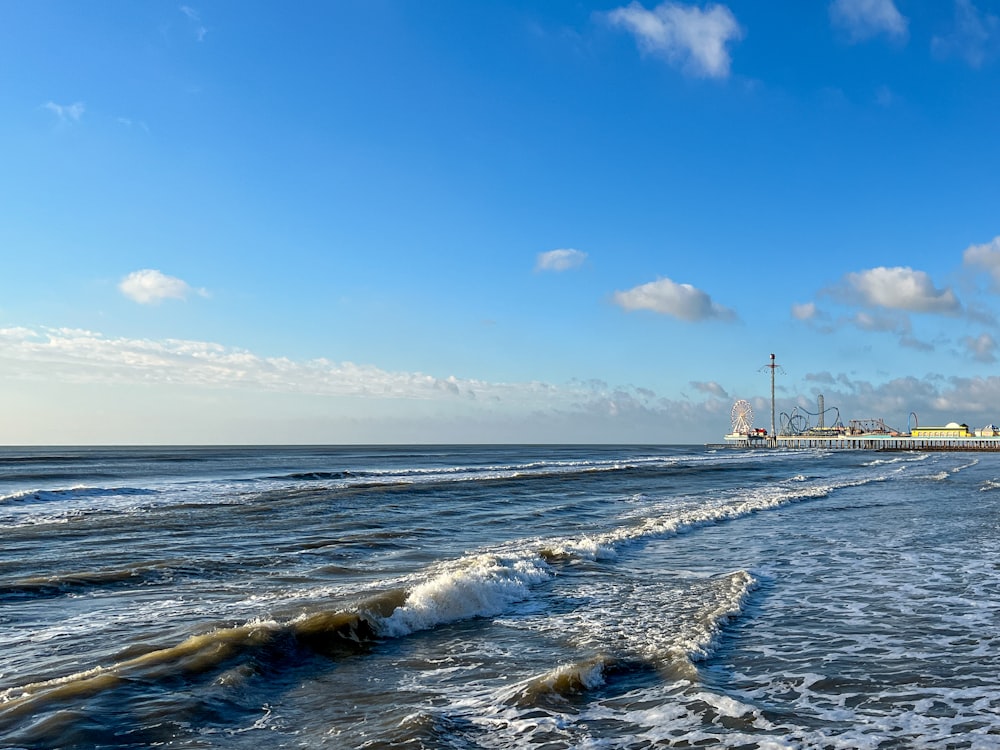 a view of a beach with a pier in the background