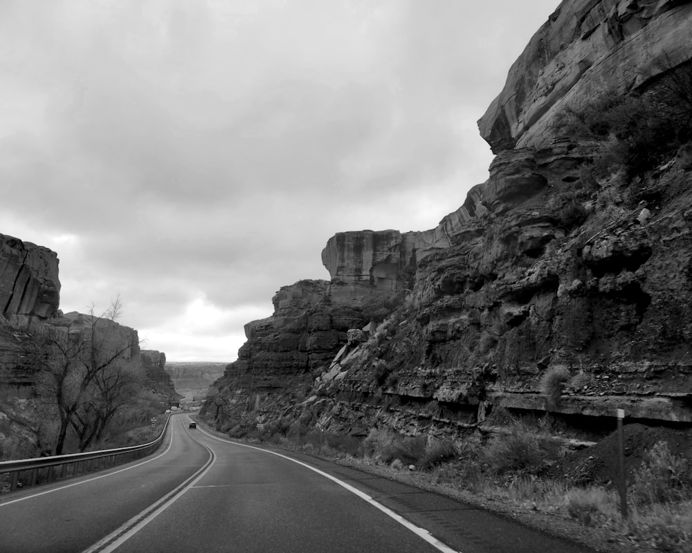 a black and white photo of a road in the mountains