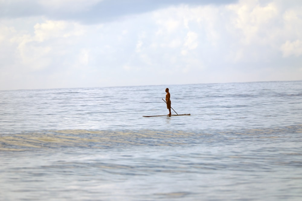a man riding a paddle board on top of a body of water