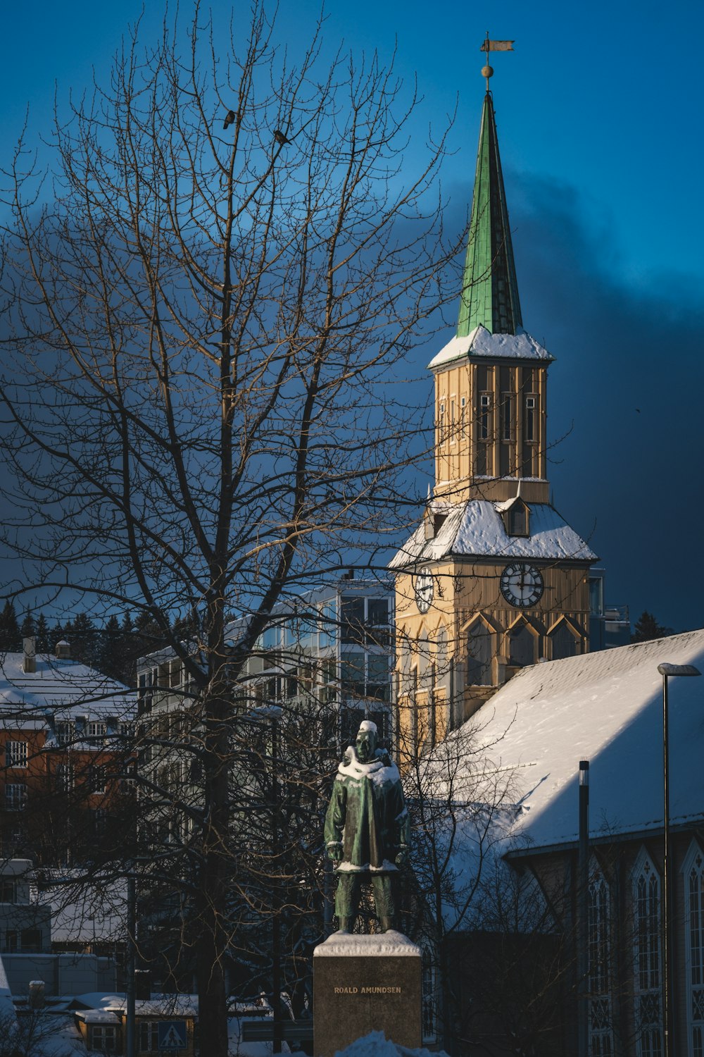a church steeple with a statue in front of it