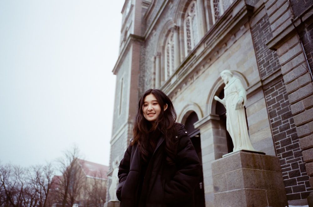 a woman is standing in front of a building