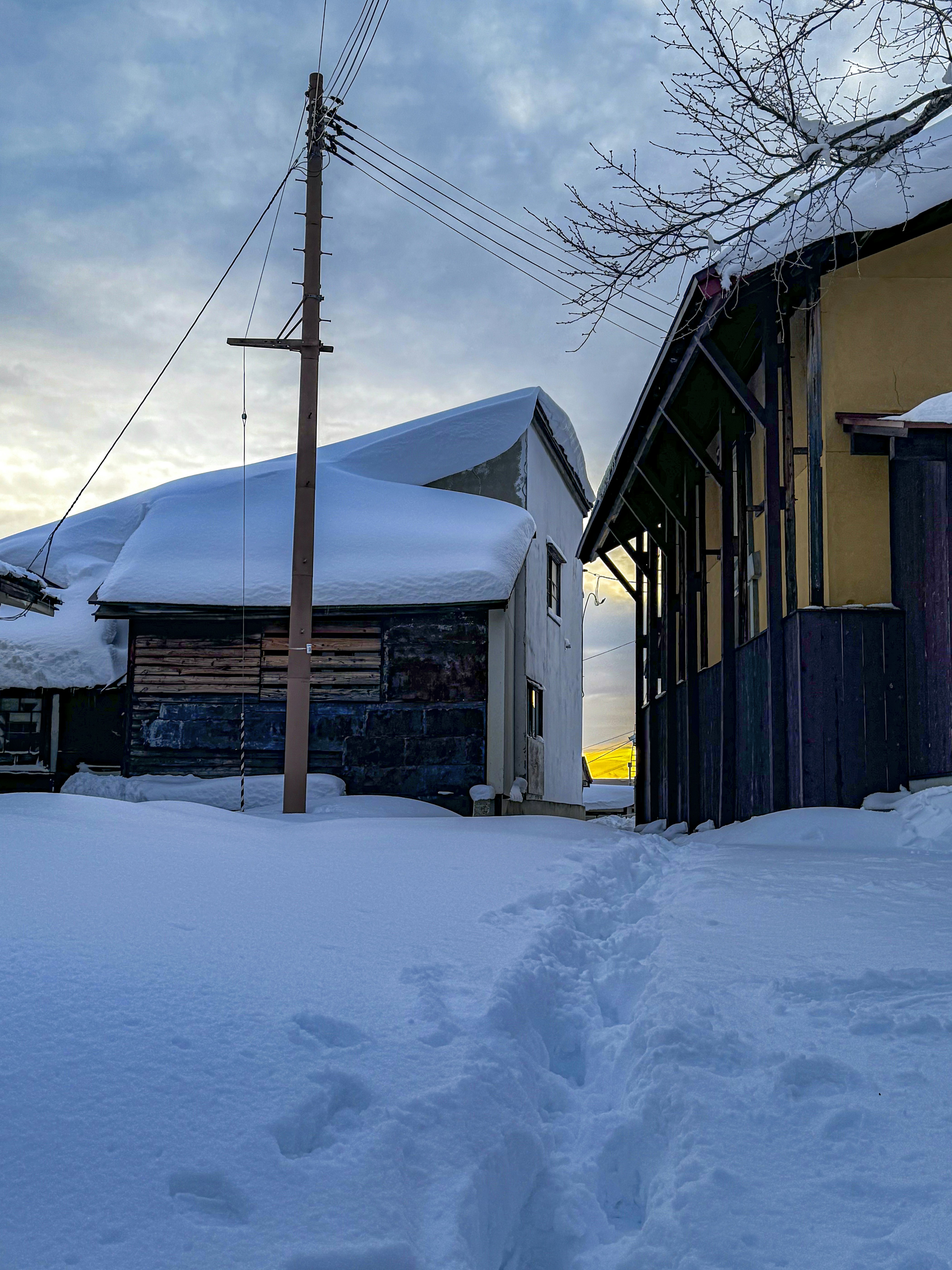 a snow covered street next to a building