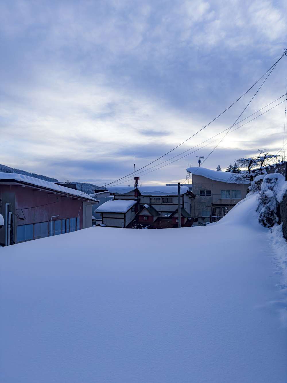 a snow covered hill with houses in the background