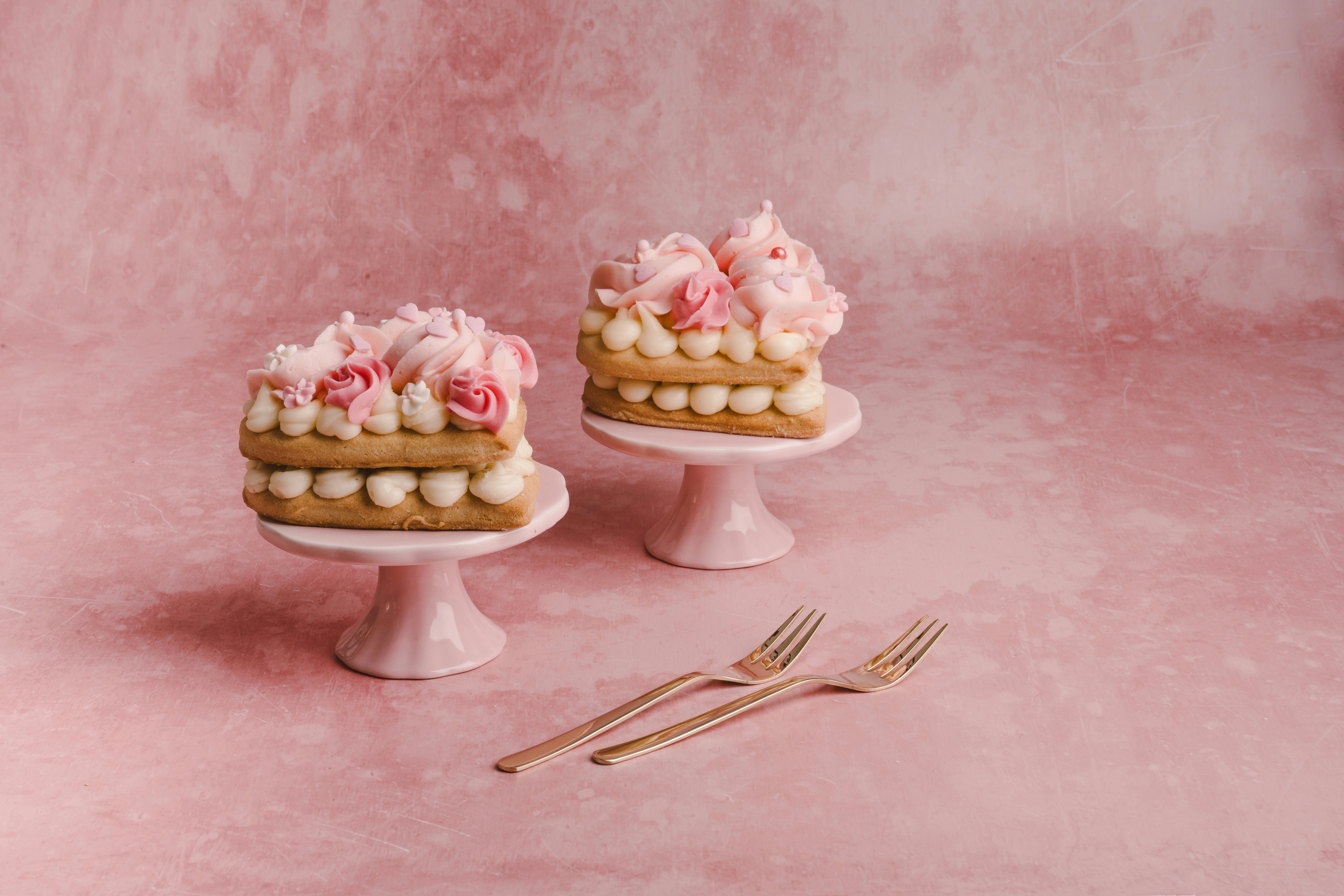 two cakes sitting on top of a white cake stand