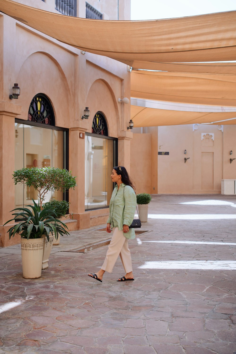 a woman walking down a street past a building