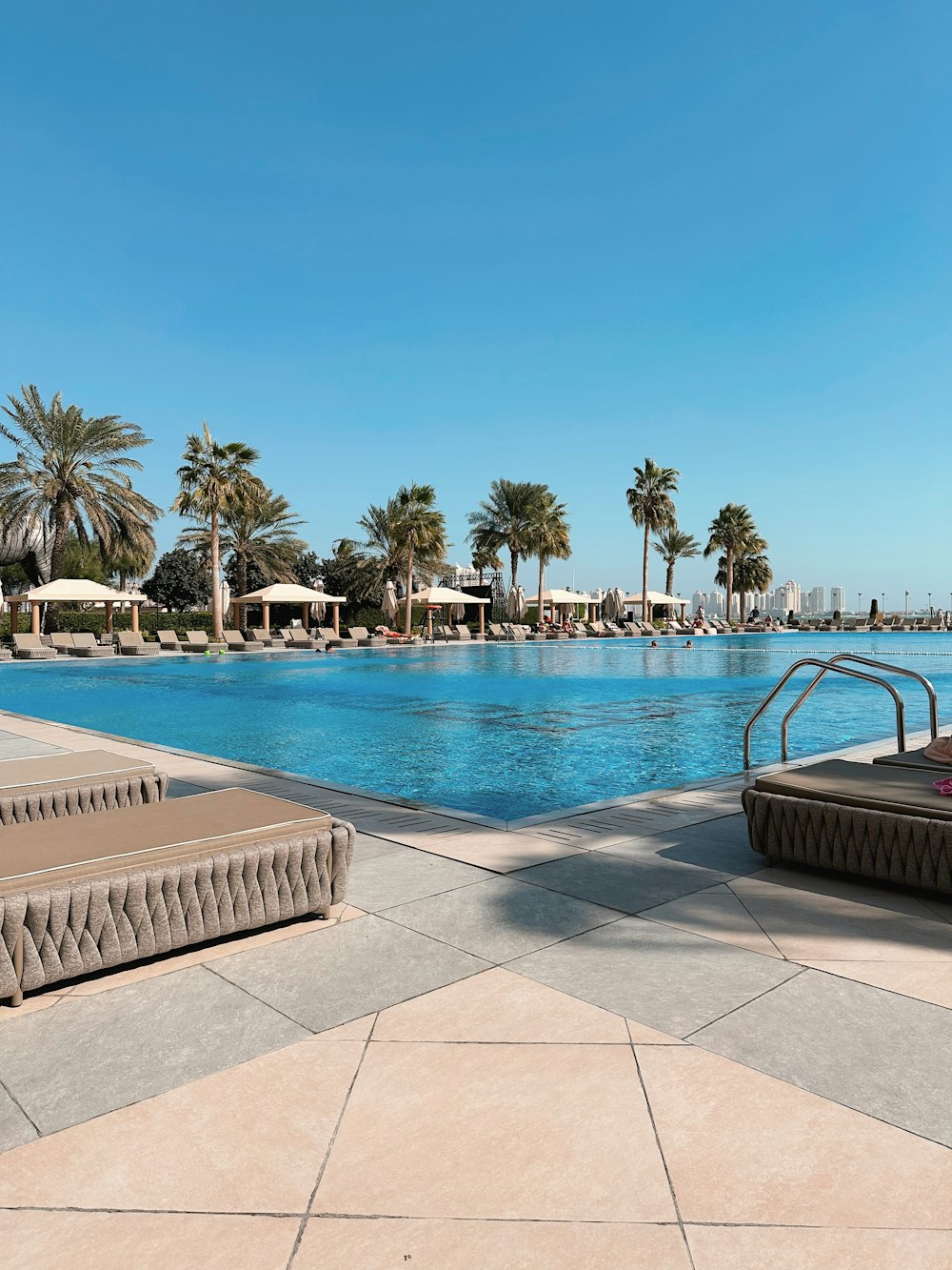 a large swimming pool surrounded by palm trees