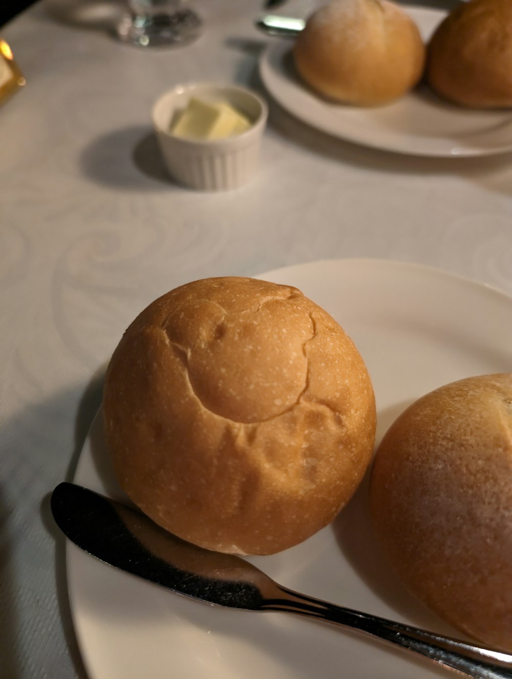 a white plate topped with two rolls and a spoon