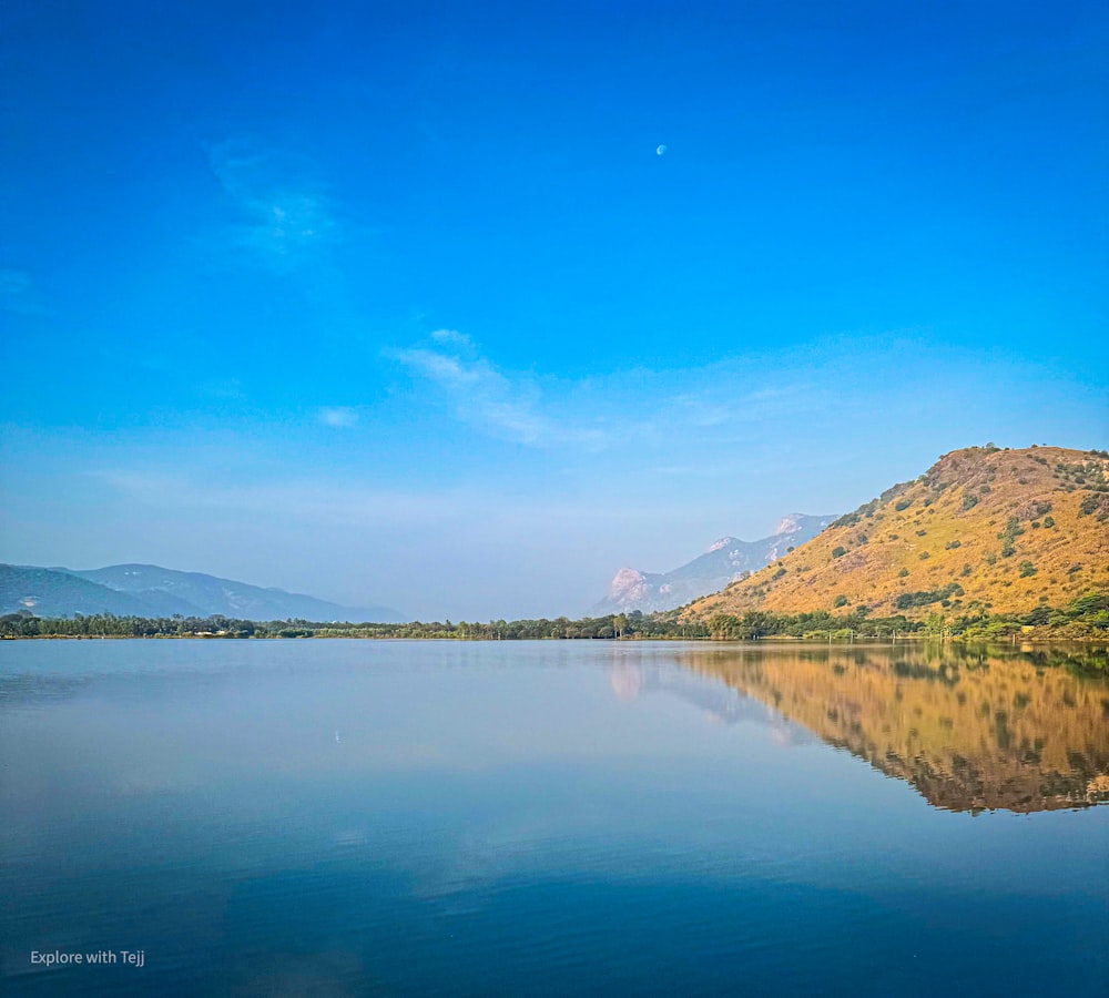 a large body of water with a mountain in the background