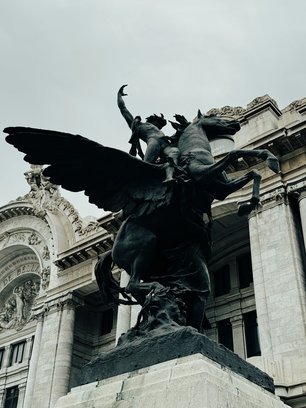 uma estátua de um homem em um cavalo na frente de um edifício