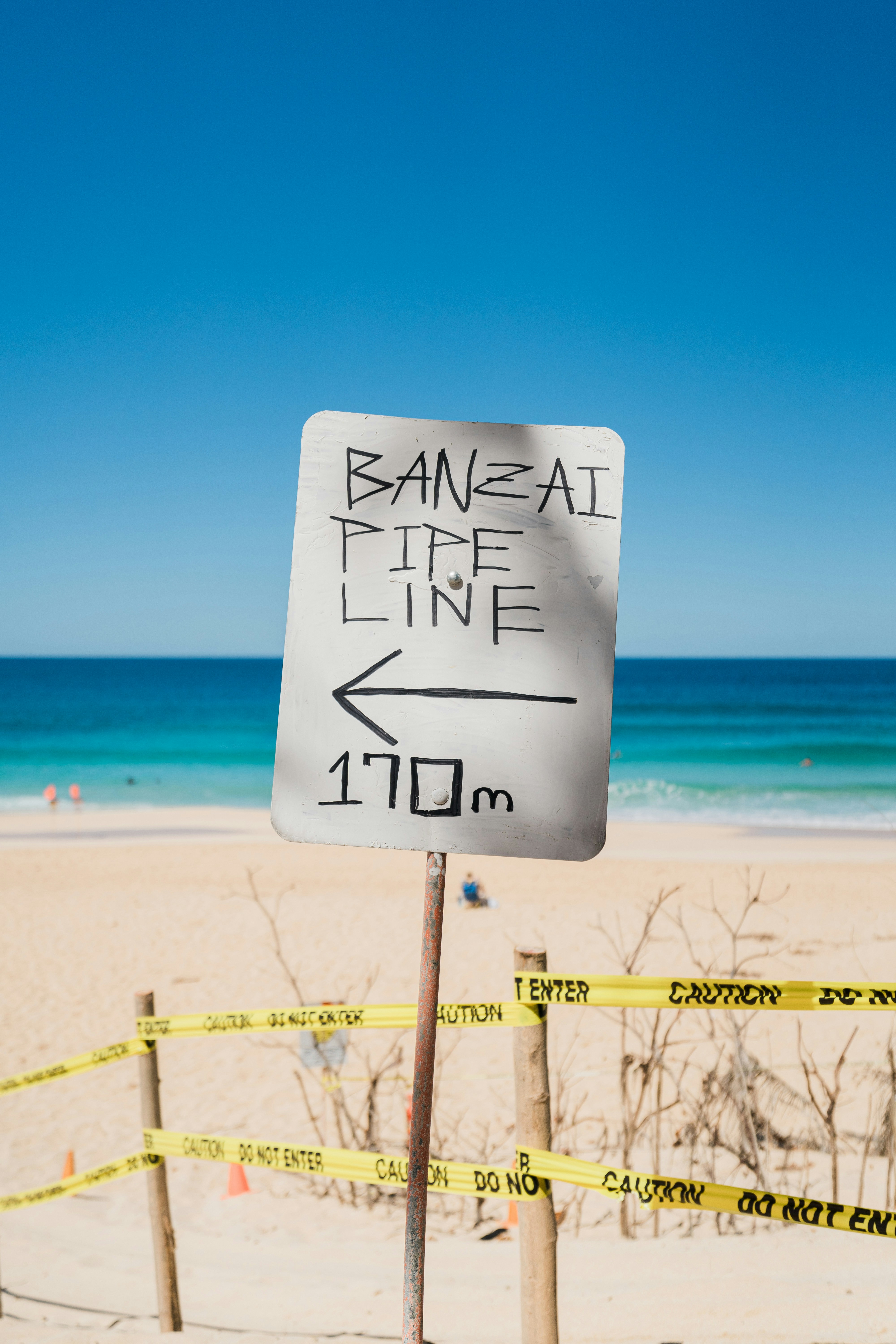 a sign that is on a post on the beach