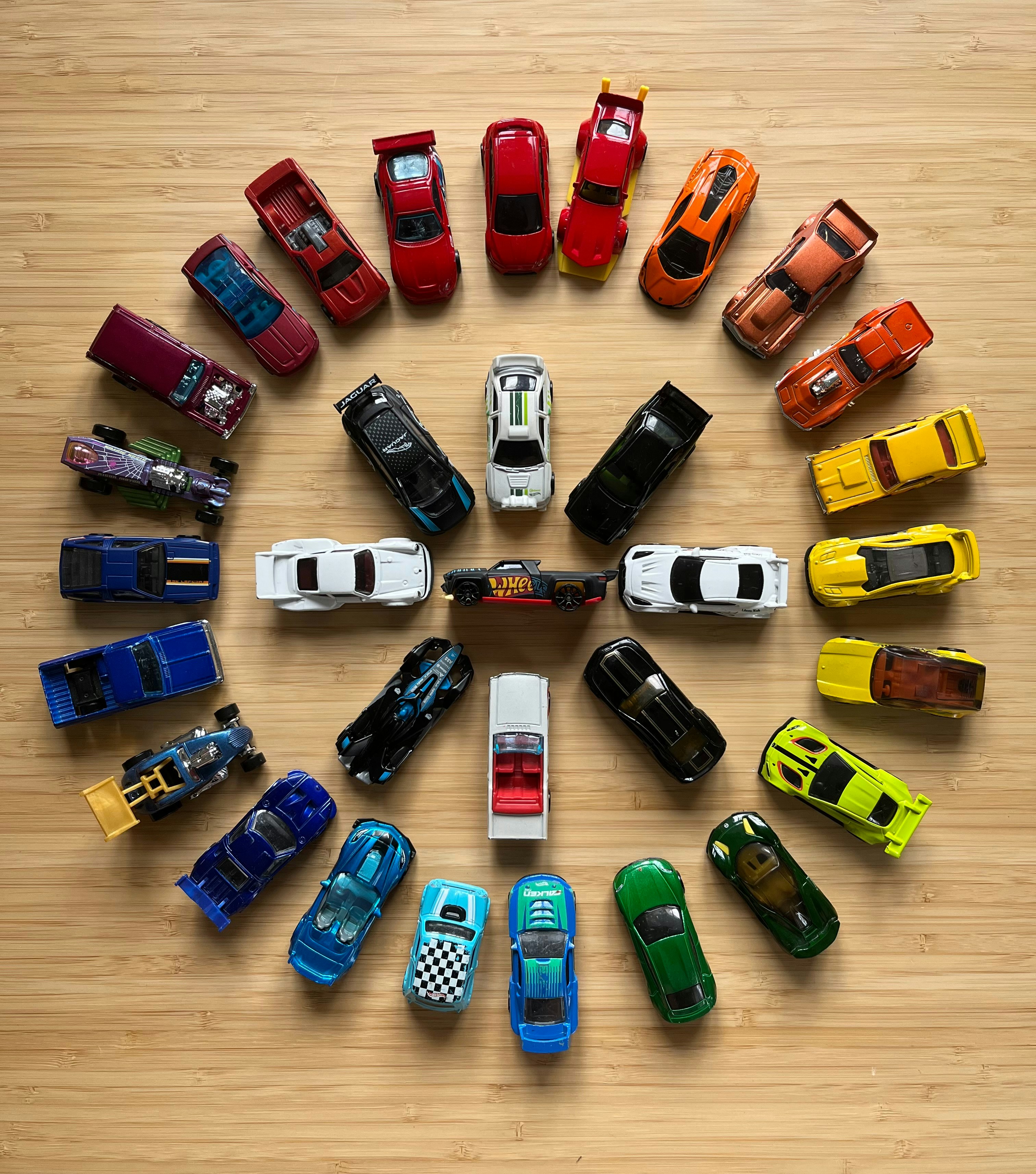 a circle of toy cars sitting on top of a wooden floor