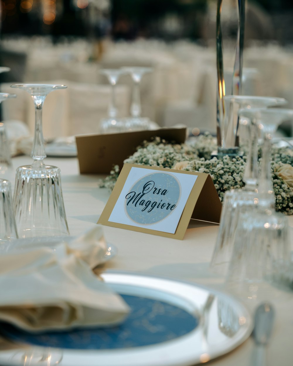a table set with place cards and wine glasses
