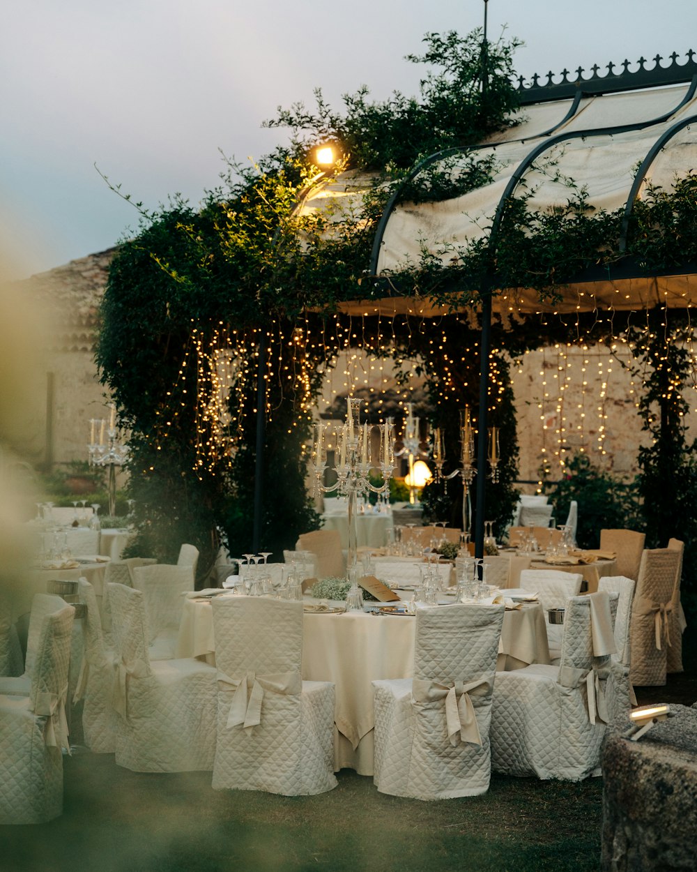 a group of tables and chairs covered in white cloths