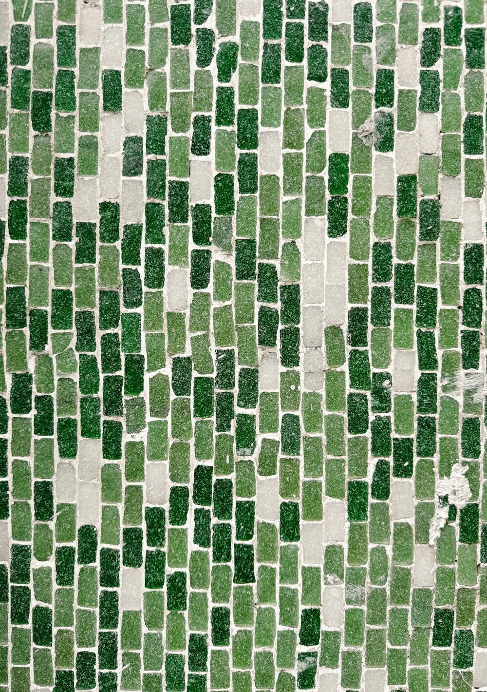 a close up of a green and white tile wall