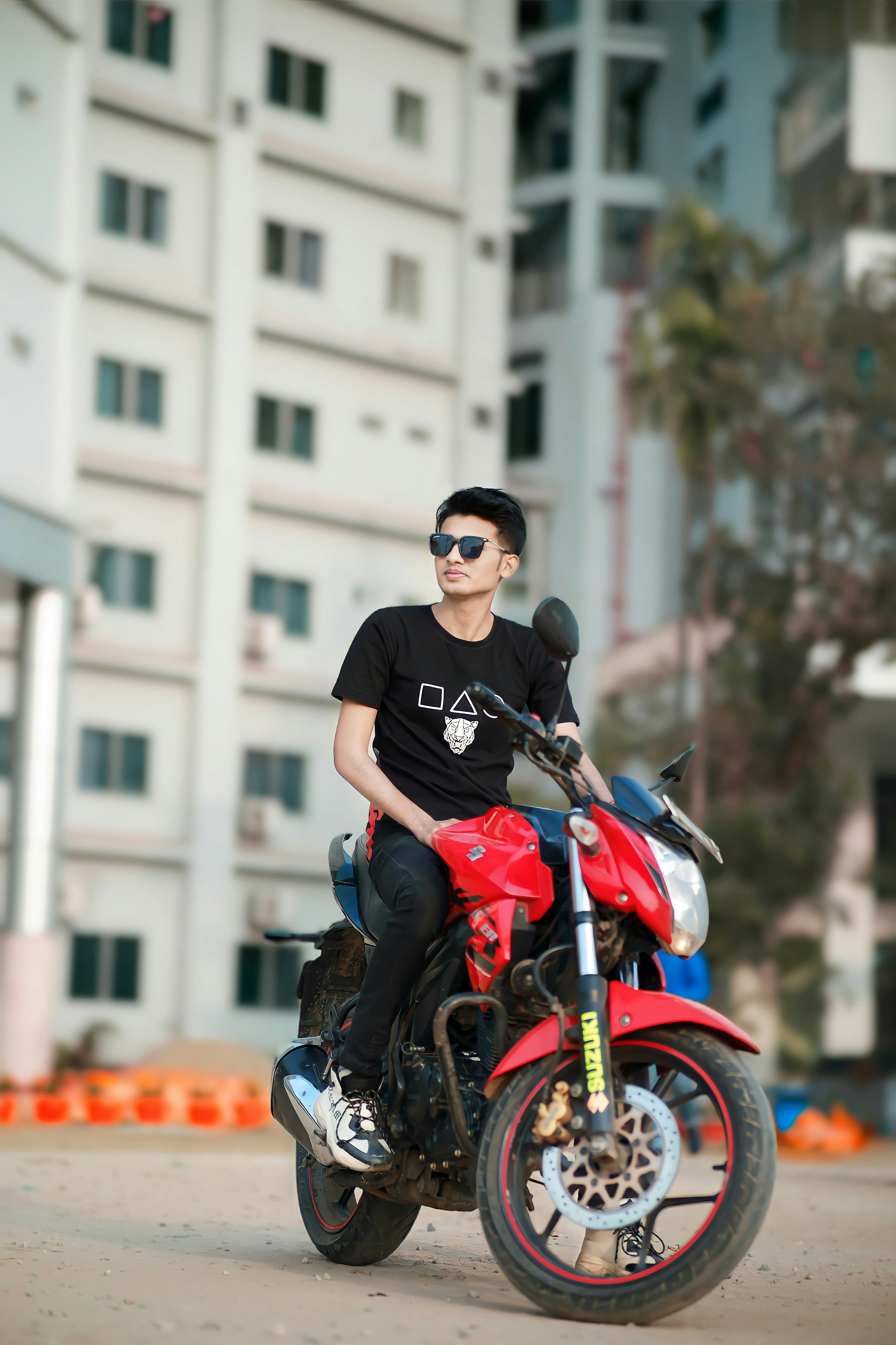 赤いバイクの後ろに乗った男