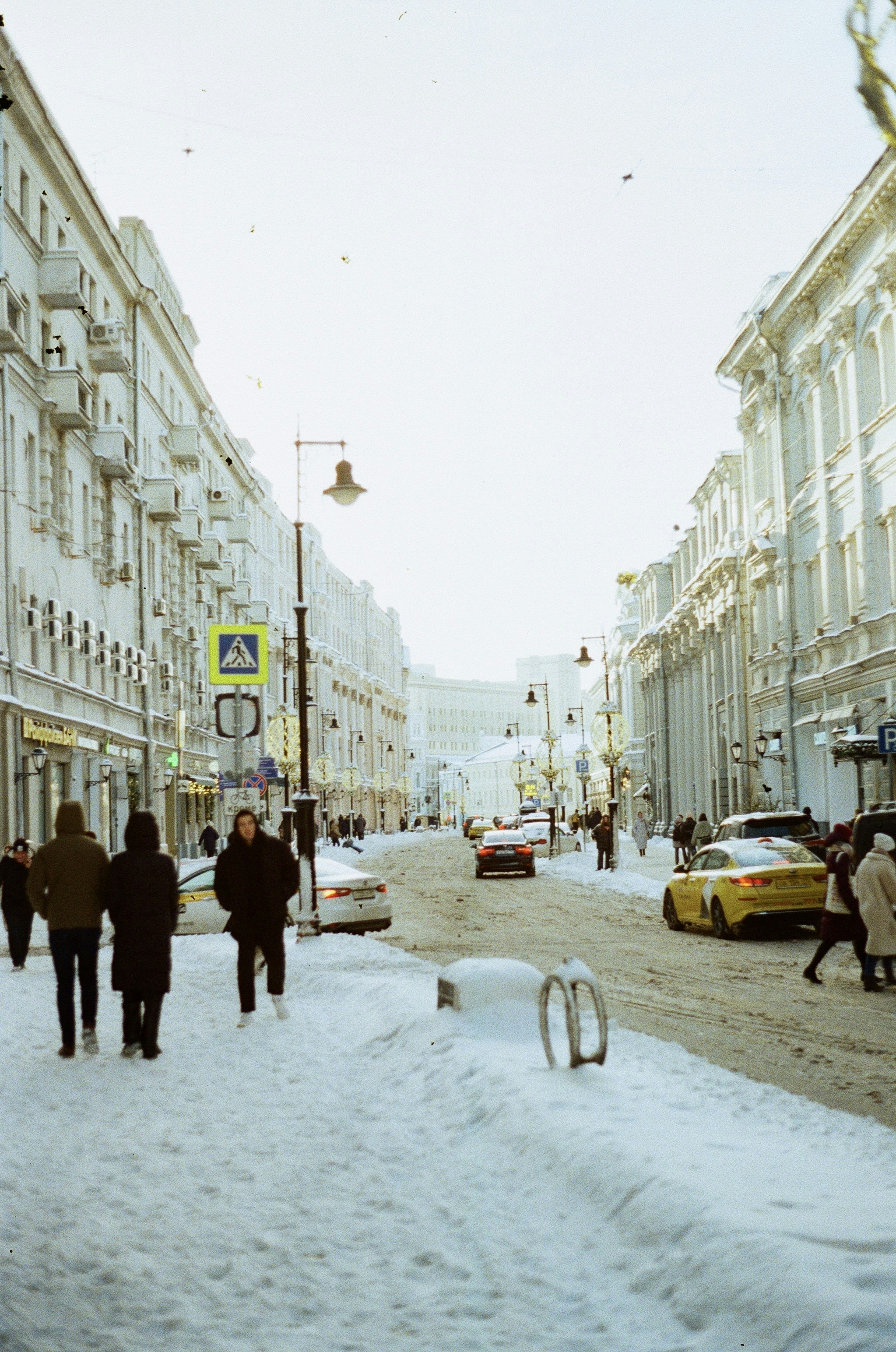 a group of people walking down a snow covered street