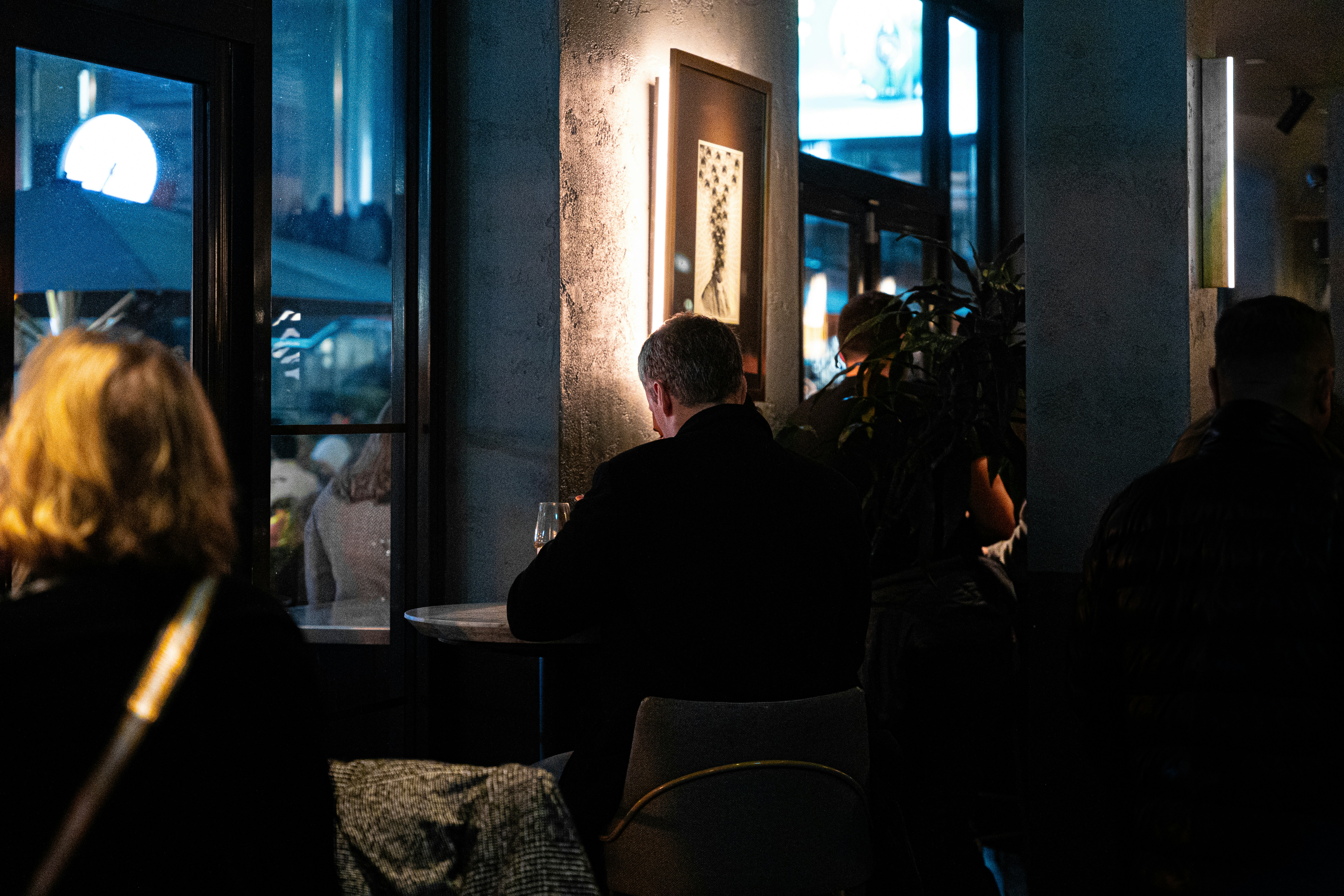 a group of people sitting at a table in a dark room