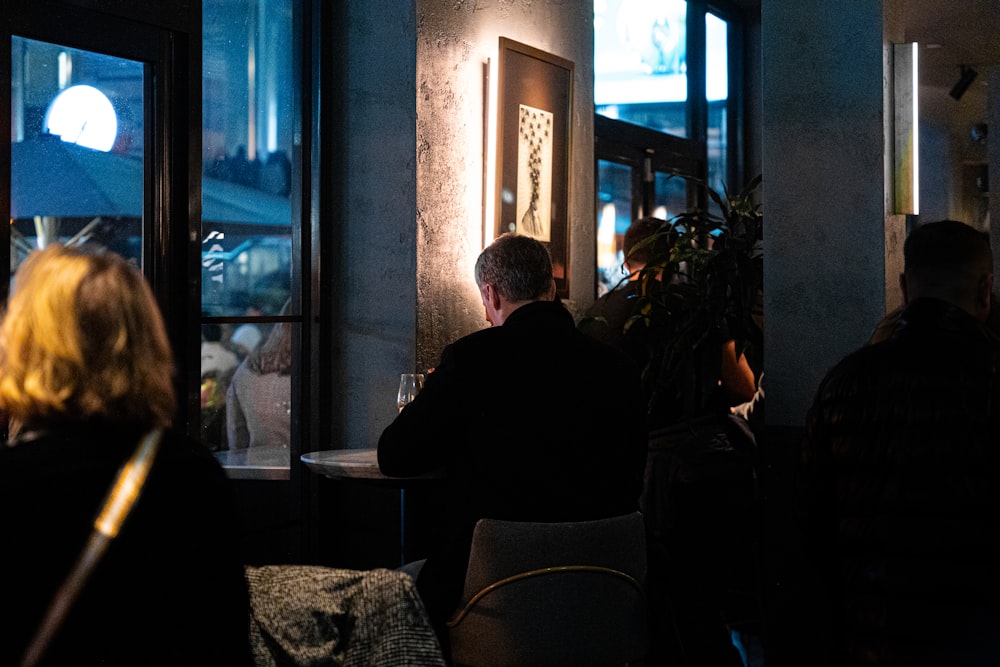 a group of people sitting at a table in a dark room