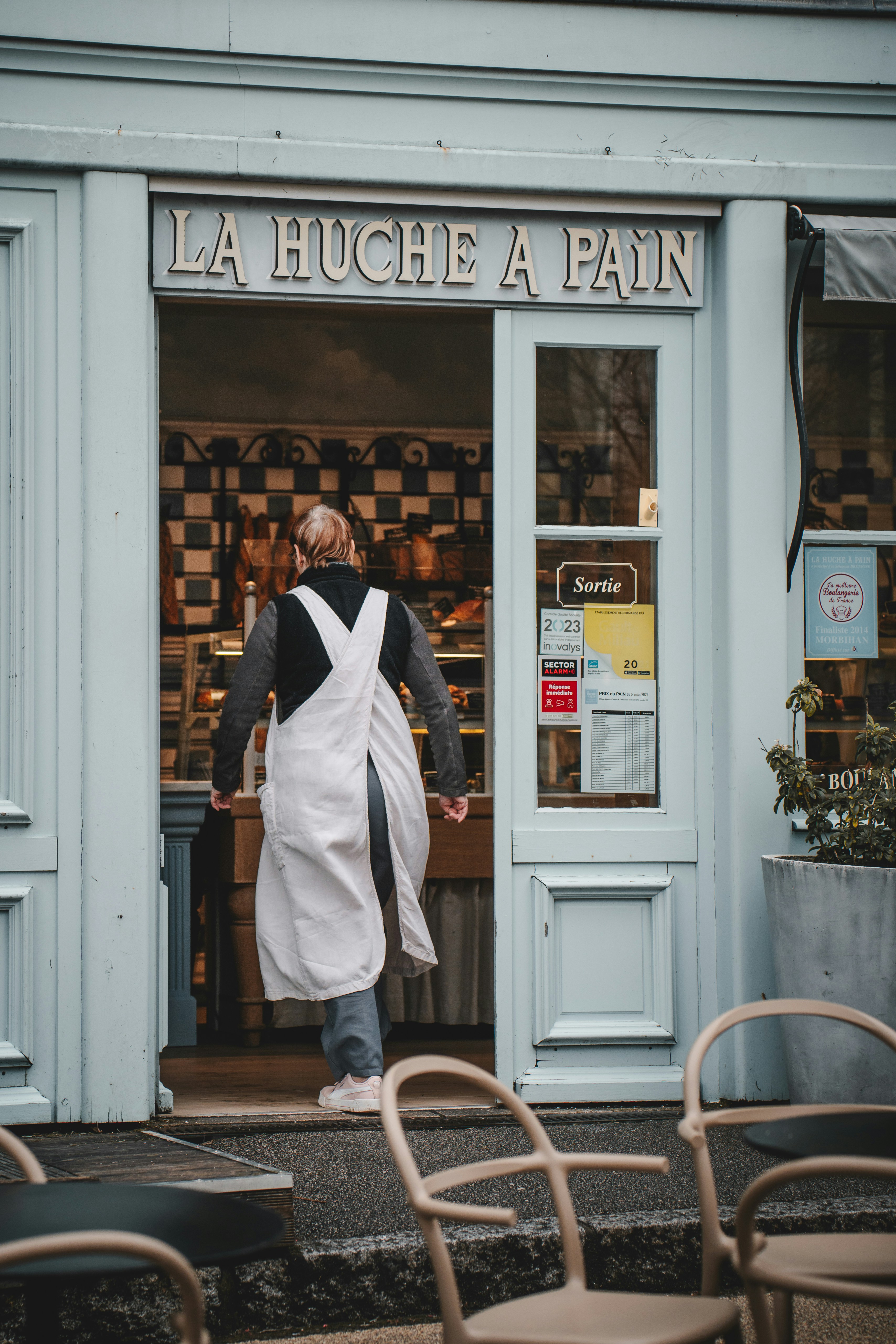 une femme en tablier sortant d’un restaurant
