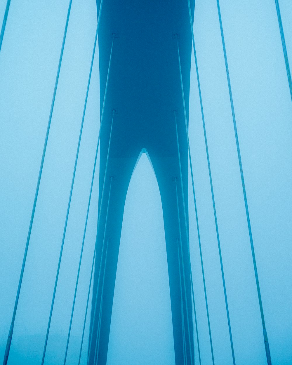 a view of a very tall bridge through the fog