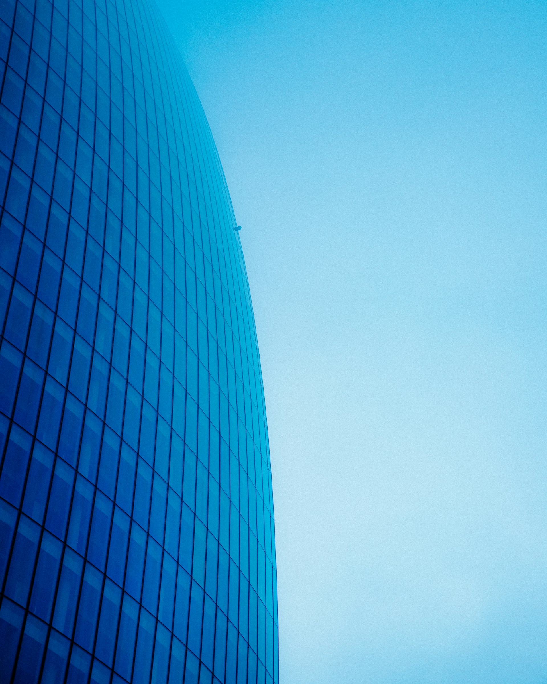 a plane flying in the sky near a building