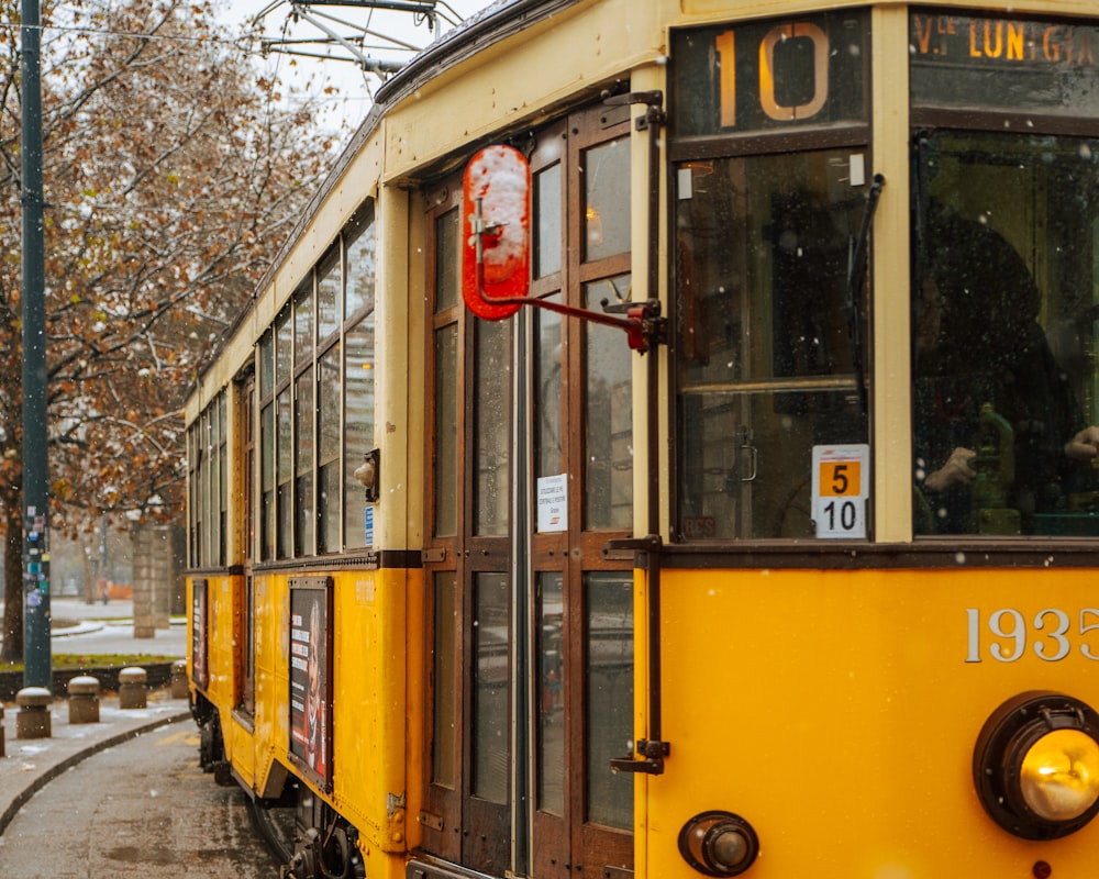 a yellow trolley car on a city street