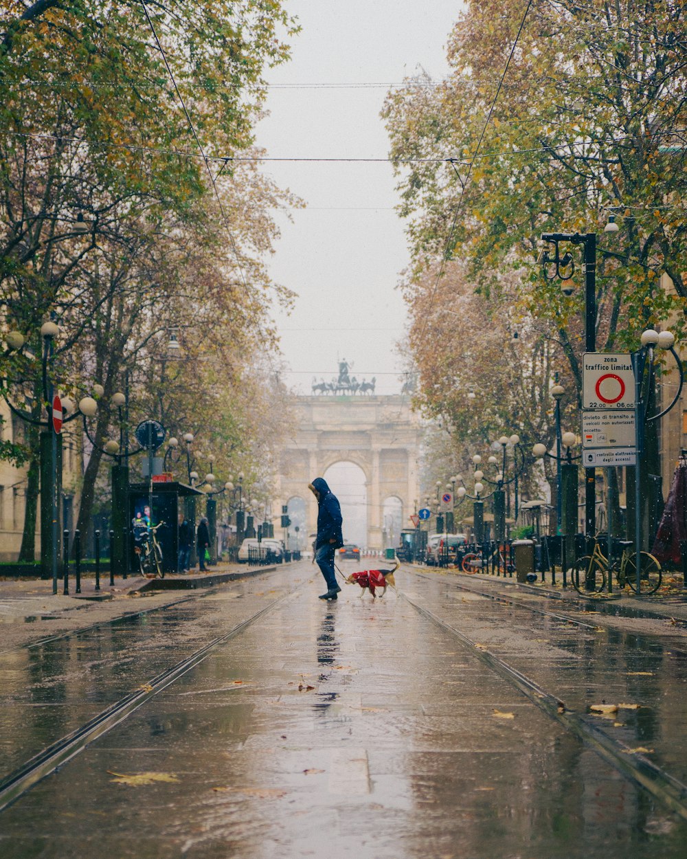 a person walking down a wet street with an umbrella