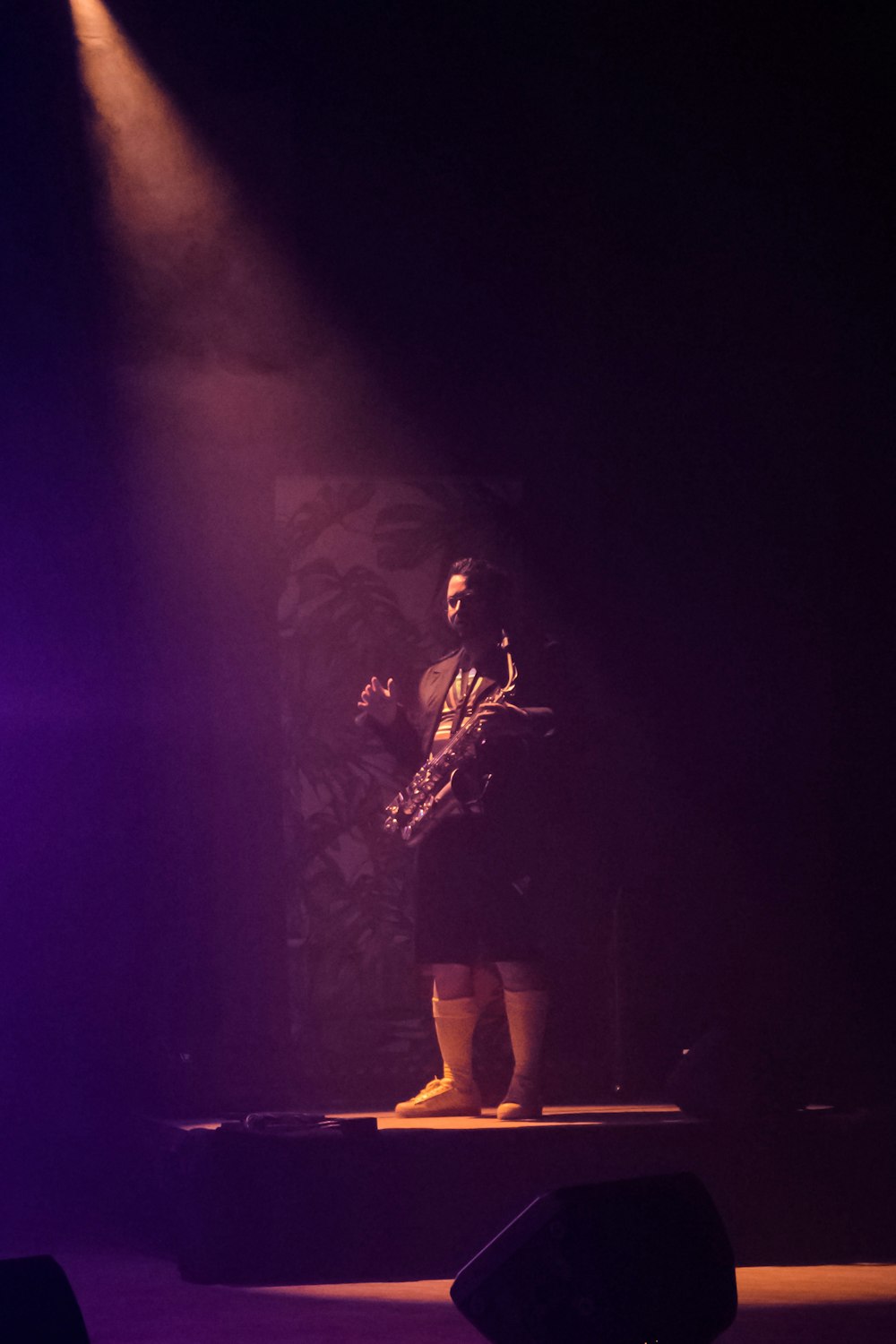 a man standing on a stage with a guitar