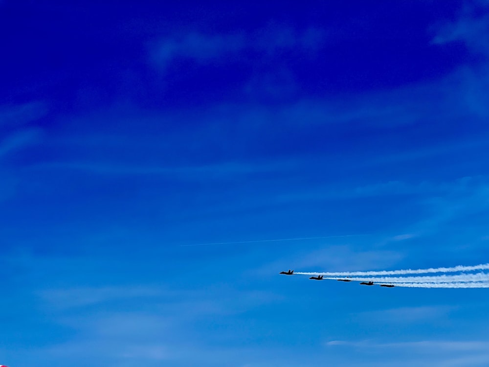 a group of airplanes flying through a blue sky