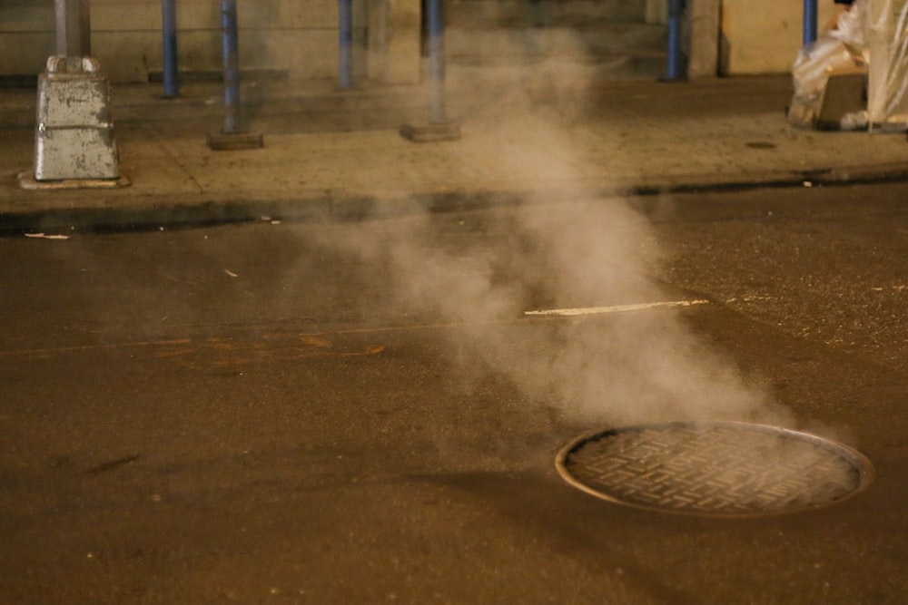 a manhole cover with steam coming out of it