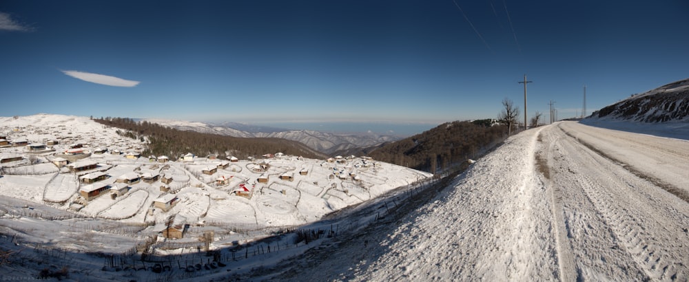 a snow covered road with a hill in the background