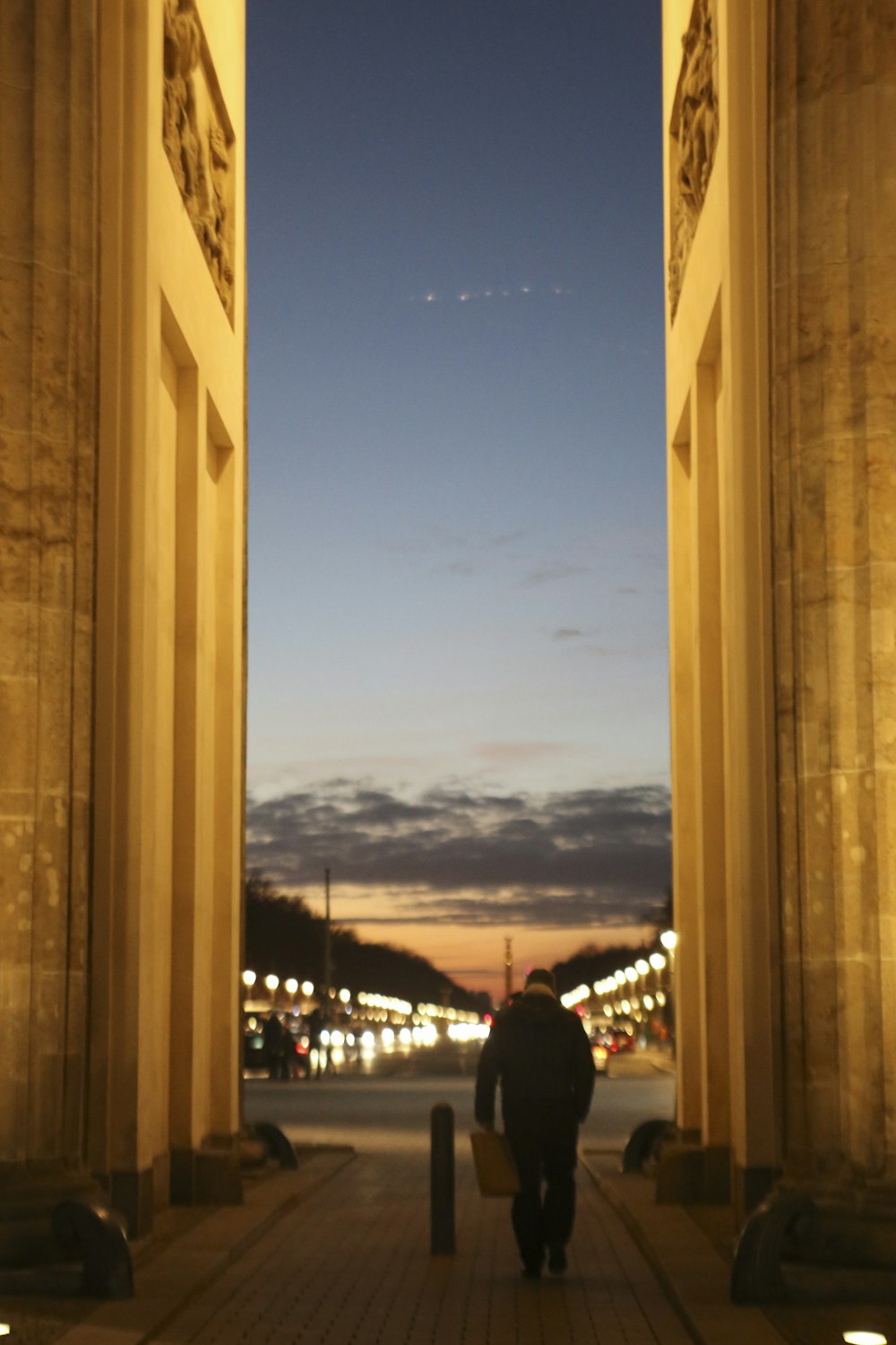 a man walking down a sidewalk at night