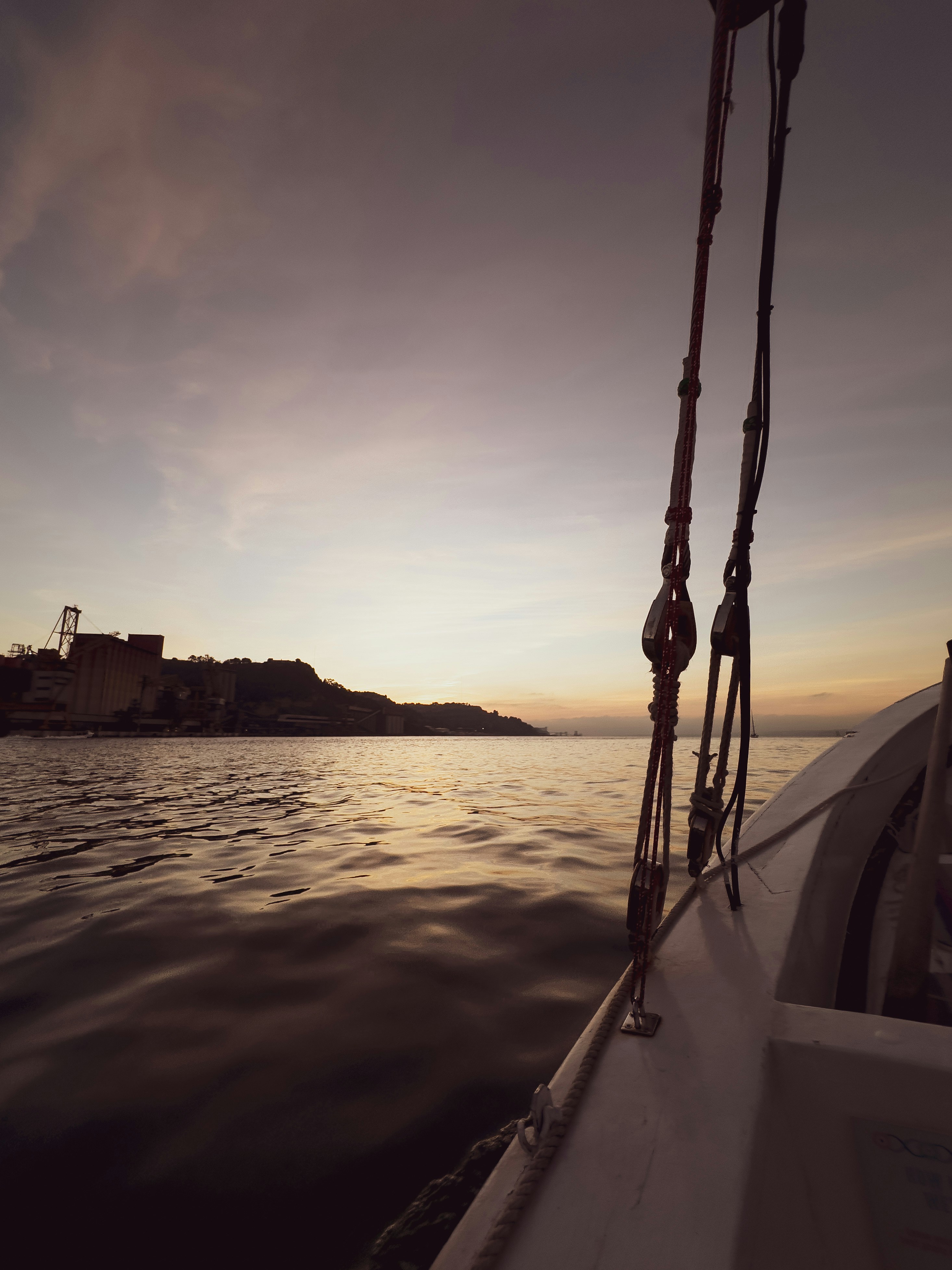 the sun is setting on a boat in the water