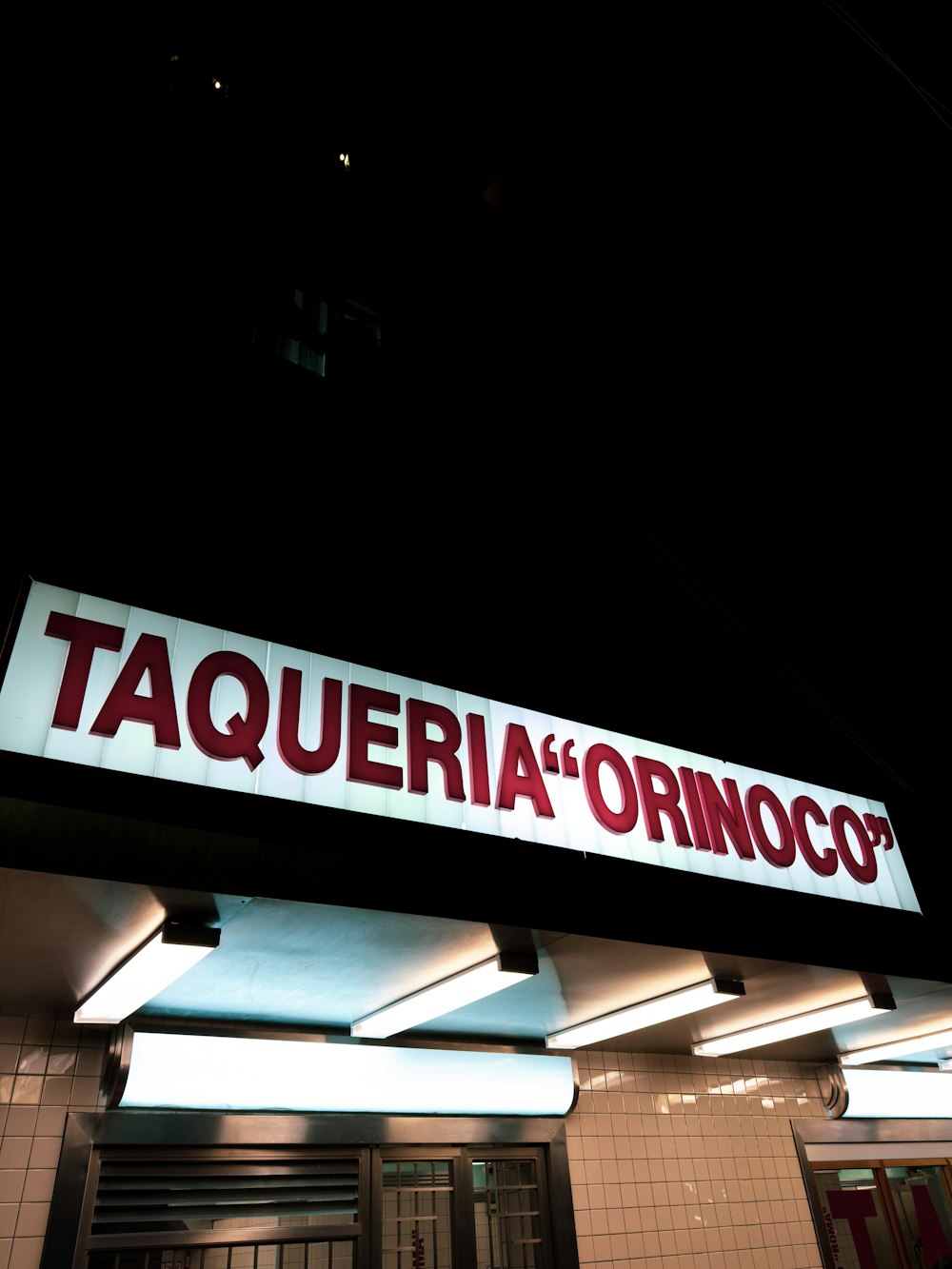 a taqueria orinoco sign lit up at night