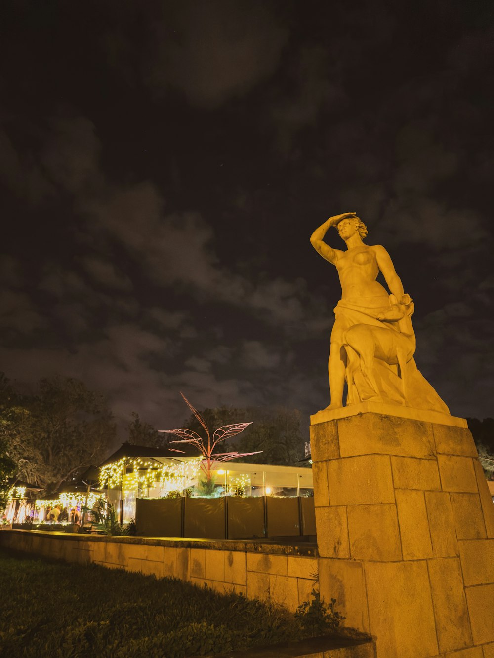 a statue of a woman is lit up at night
