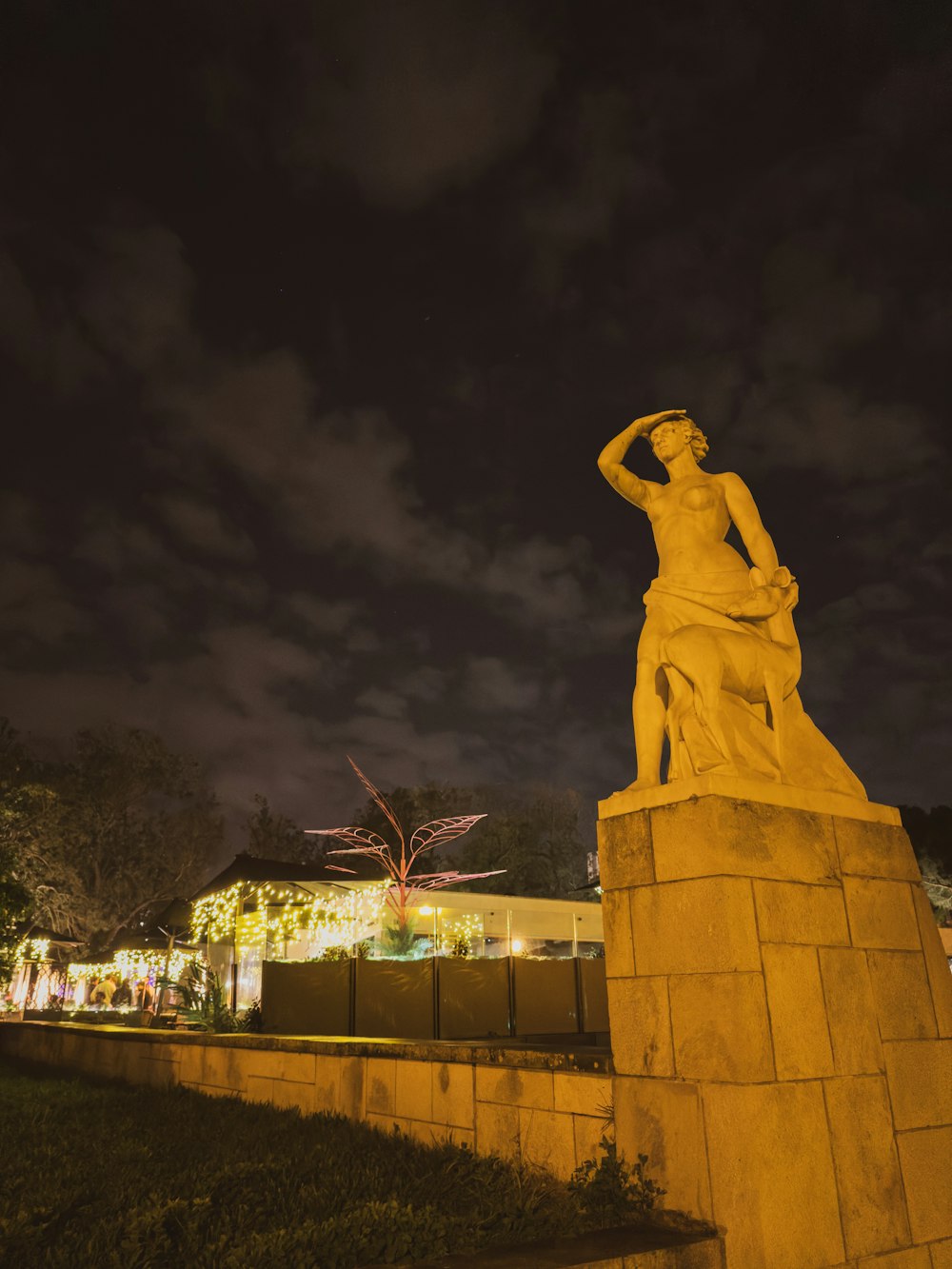 Una statua di una donna è illuminata di notte