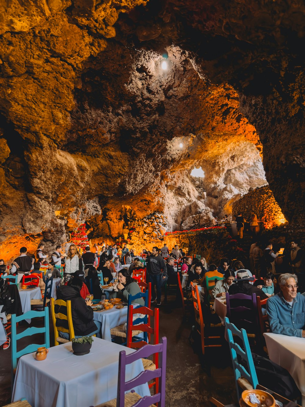a group of people sitting at tables in a cave