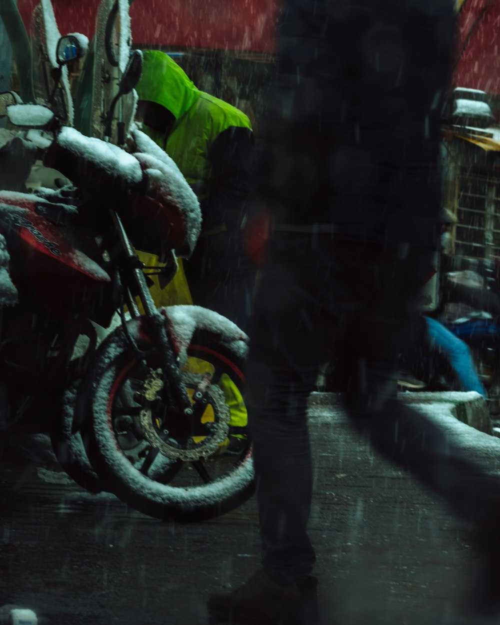 a person standing next to a motorcycle in the snow