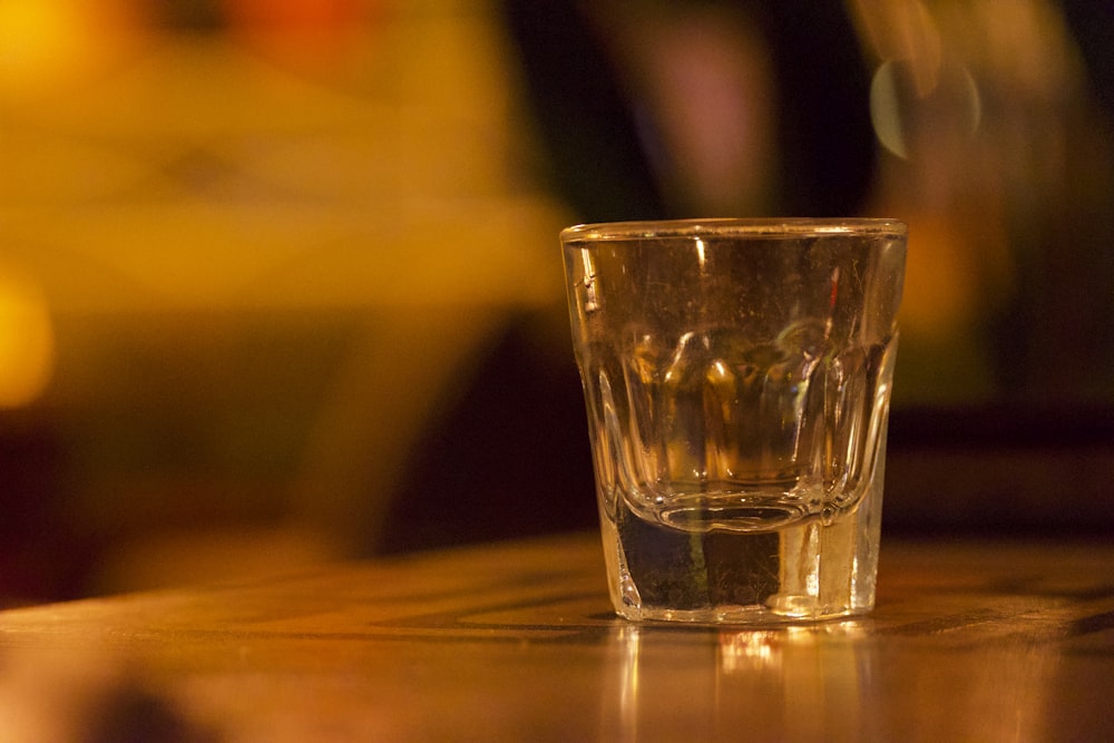 a shot glass sitting on top of a wooden table