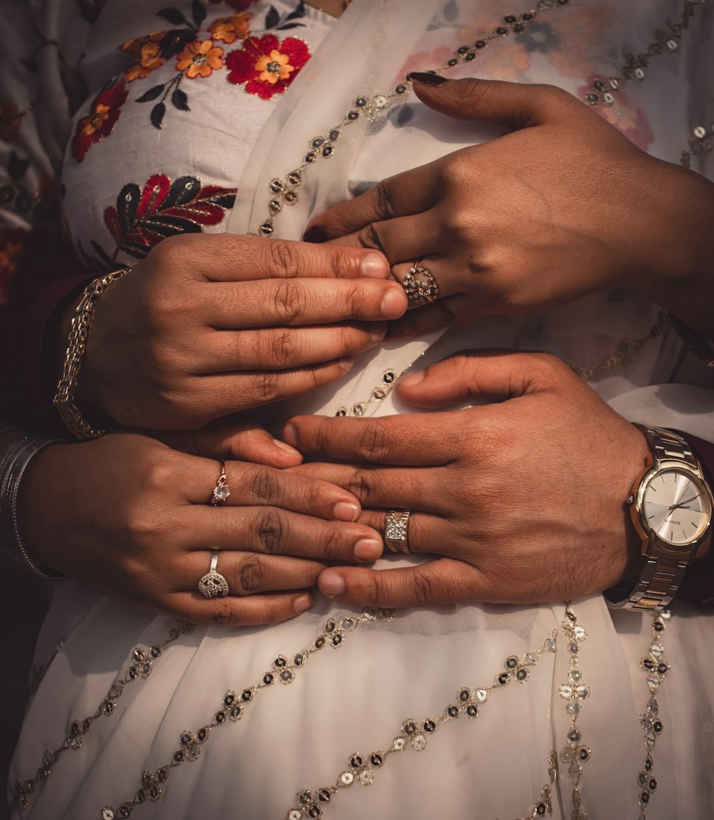 a close up of two people wearing rings