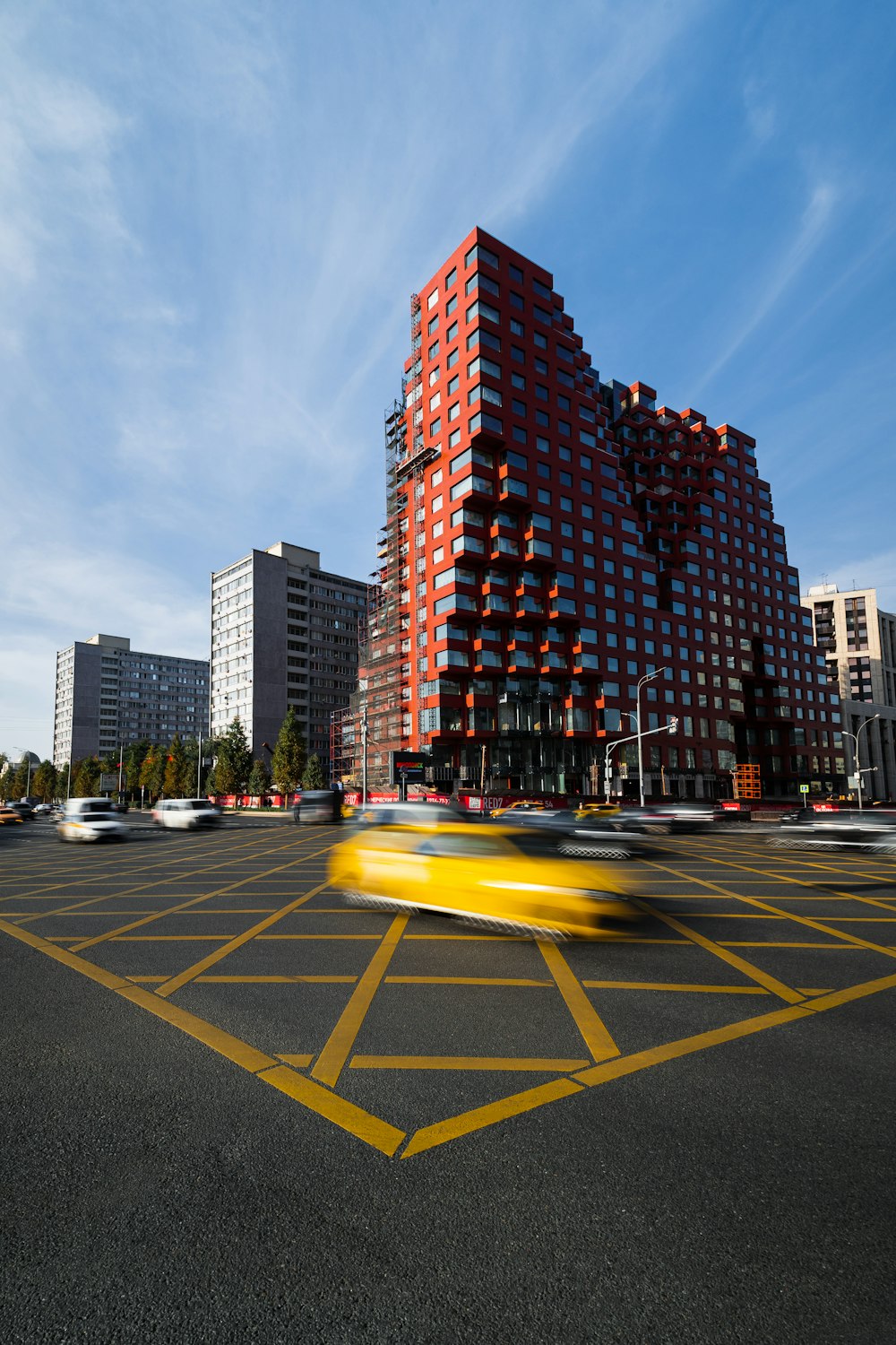 a yellow taxi drives through a parking lot