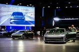 a group of people standing around a bunch of cars